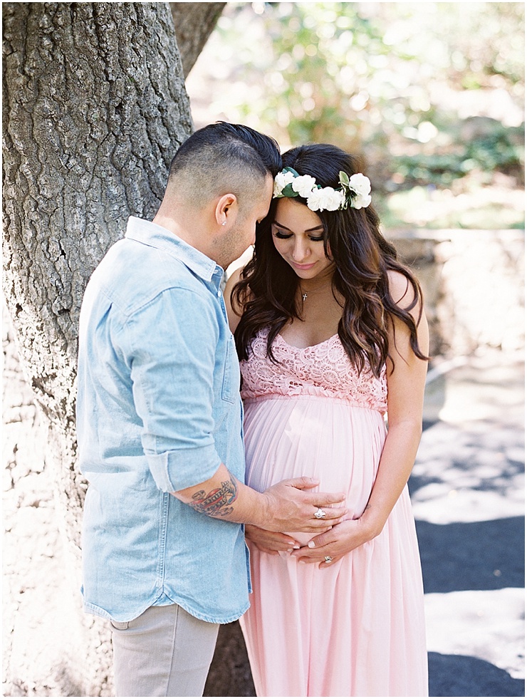 A man touches his pregnant wife's belly during their Malibu maternity session.