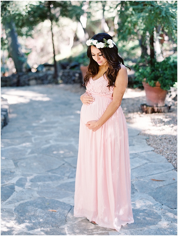 Maternity session image of a mother to be in a pink dress with a white floral crown.