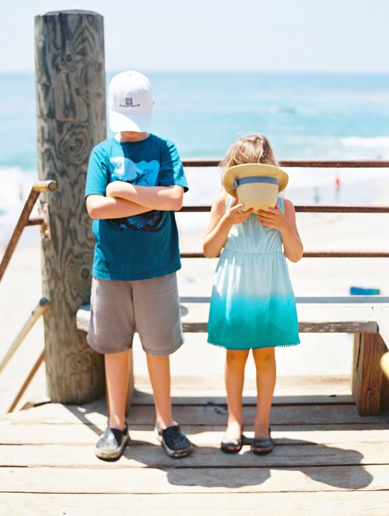 Siblings who don't want their photo taken at their children's portrait session in Malibu