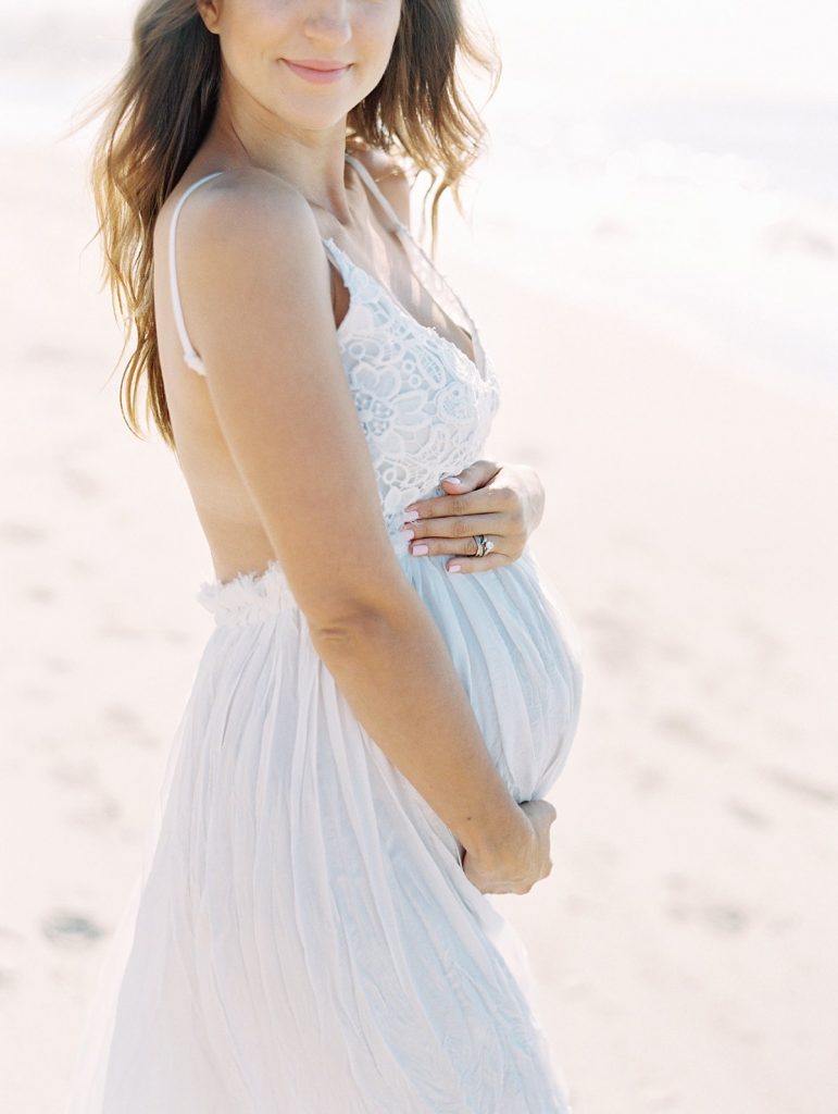 An expectant mother holds her belly during her Santa Barbara maternity portraits