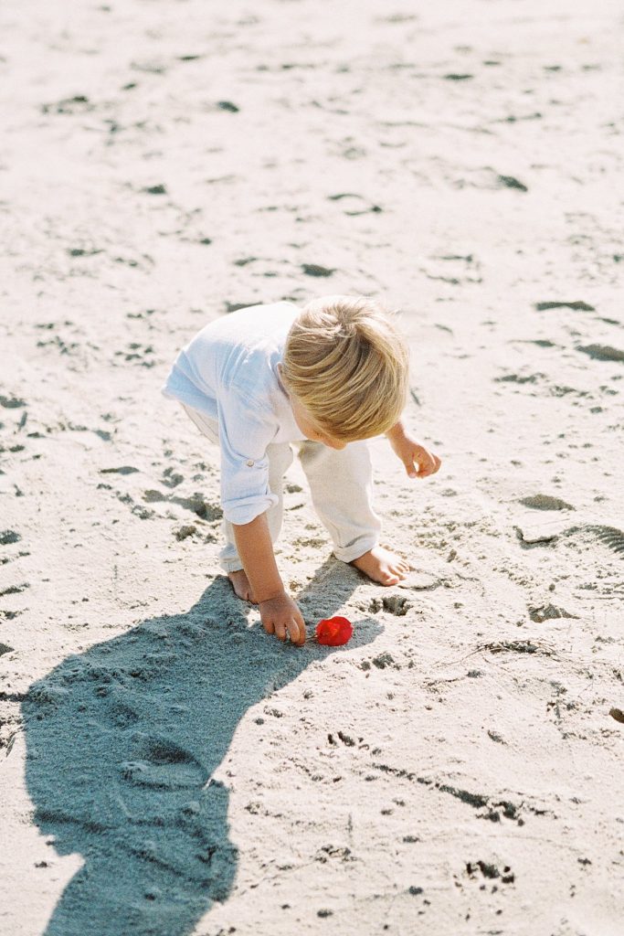 Santa Barbara family photographer Daniele Rose captures a little boy dressed in white on the beach