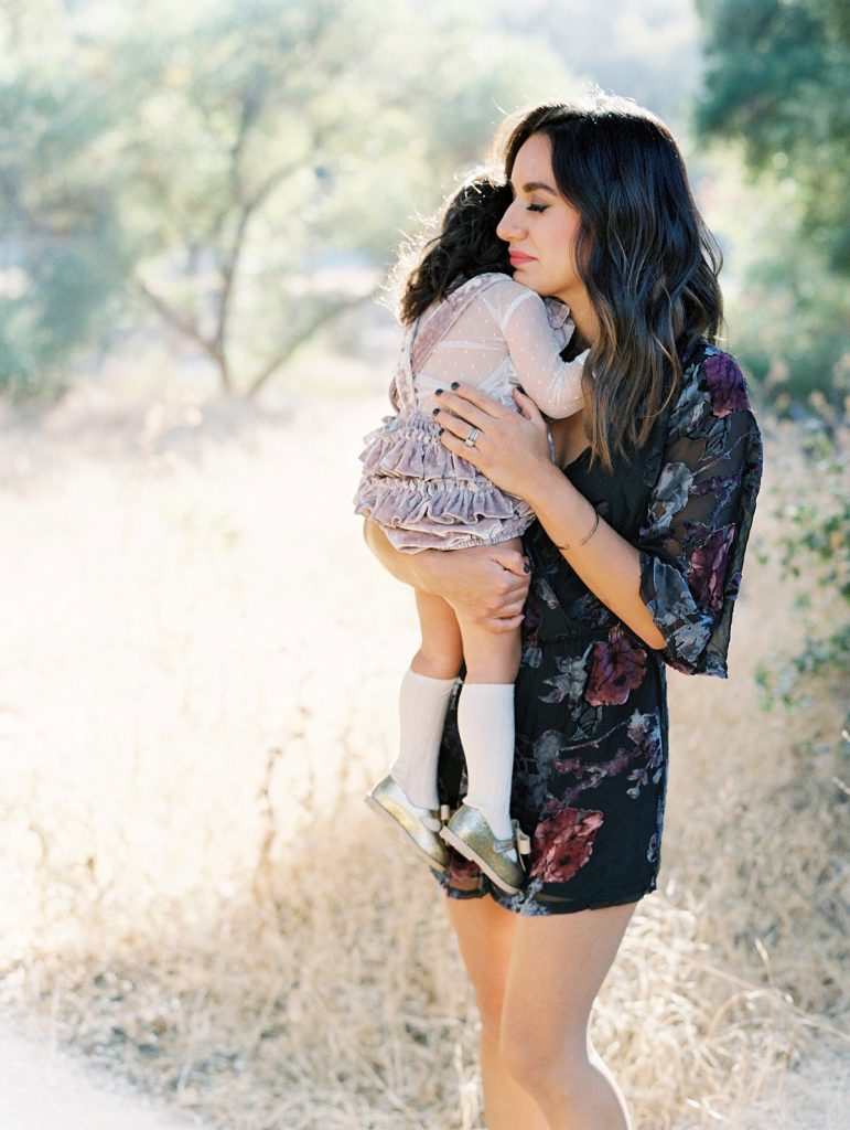 A mother hugs her young daughter during their family portrait session in Thousand Oaks