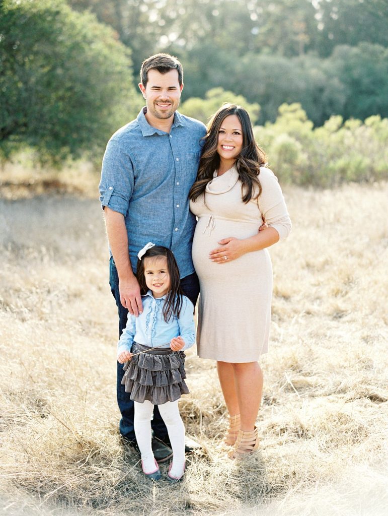 A family poses in a golden field in Thousand Oaks for their family portrait session