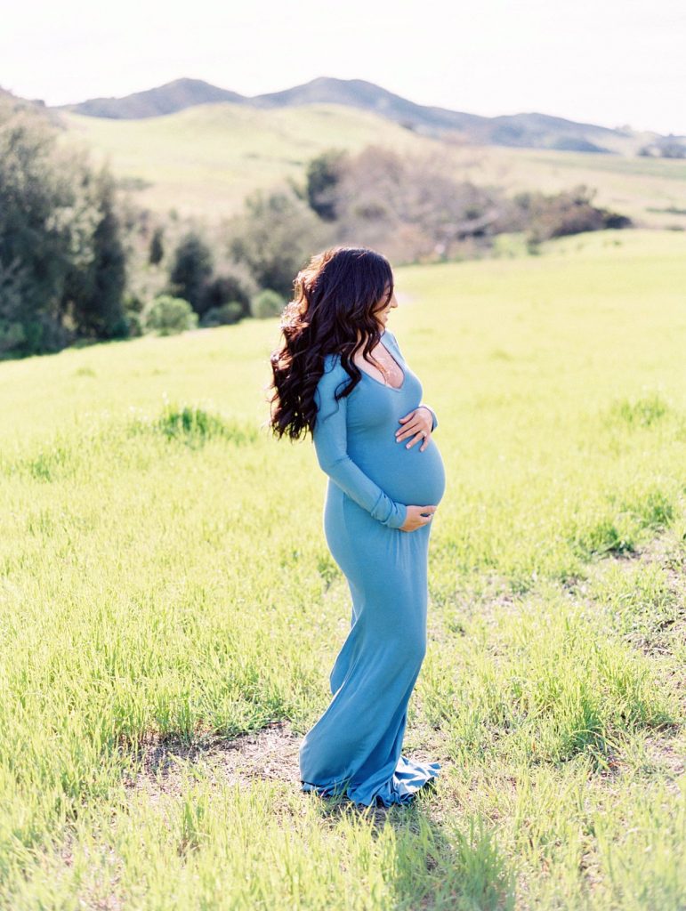 A maternity image of an expectant mother in the rolling green hills of Thousand Oaks