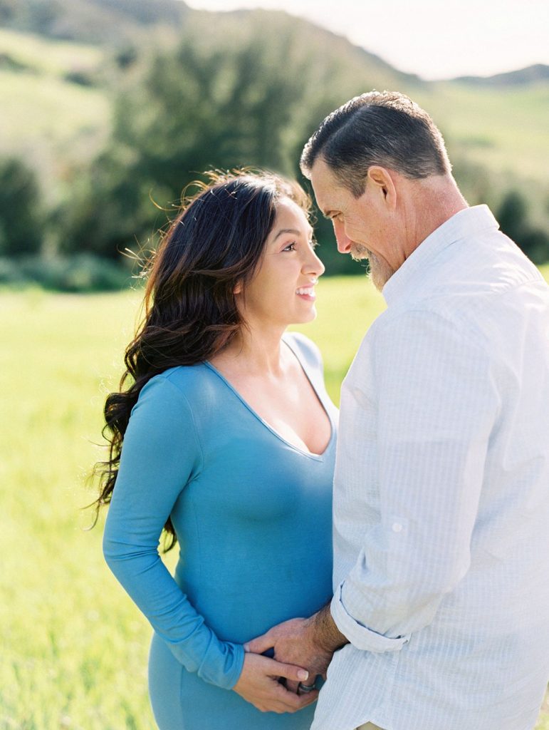 A mother to be looks lovingly at her husband during their maternity portrait session