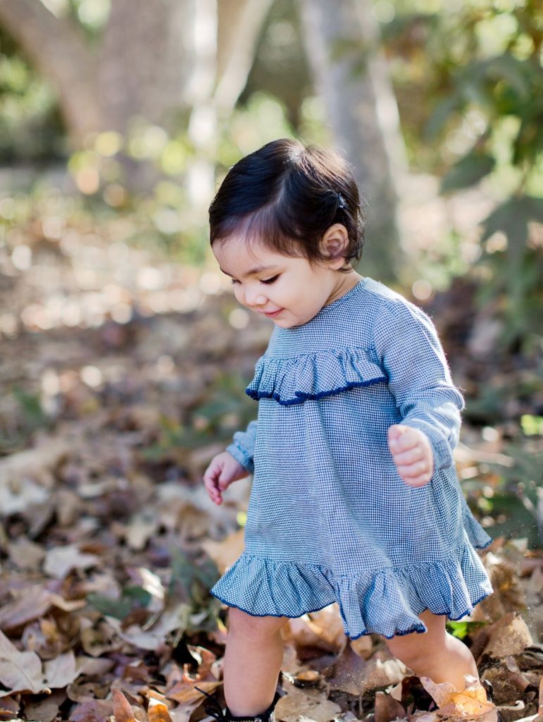 A young girl walks through leaves at Foster Park