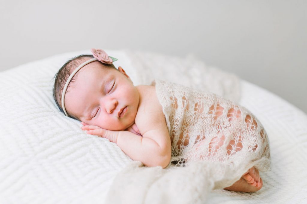 A newborn baby wearing a simple headband during her newborn portrait session with Camarillo photographer Daniele Rose.