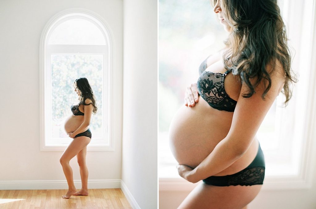 What to wear for a maternity photo session post photo of an expectant mother posing in black lingerie in front of an arched window.