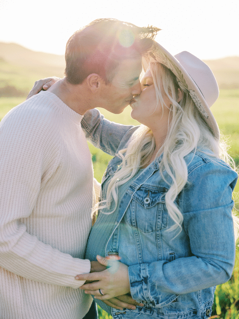 Couple kissing in the golden sunlight during their spring family portrait session in Ventura County.