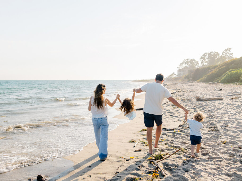 Family walking and playing together during a natural Santa Barbara beach photography session