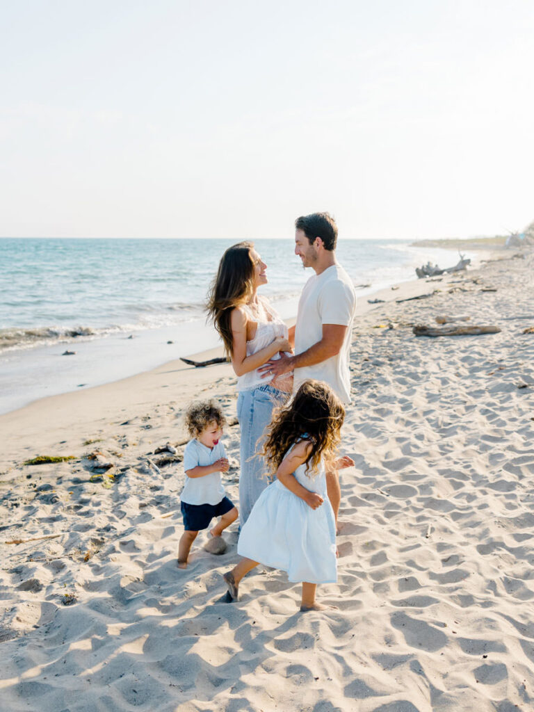 Kids running and playing while their parents cuddle during relaxed Santa Barbara family photos